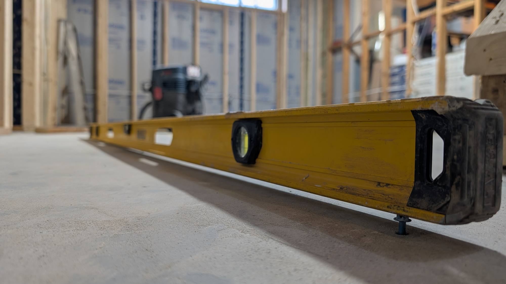 Level set on a poured basement floor during a framing stage