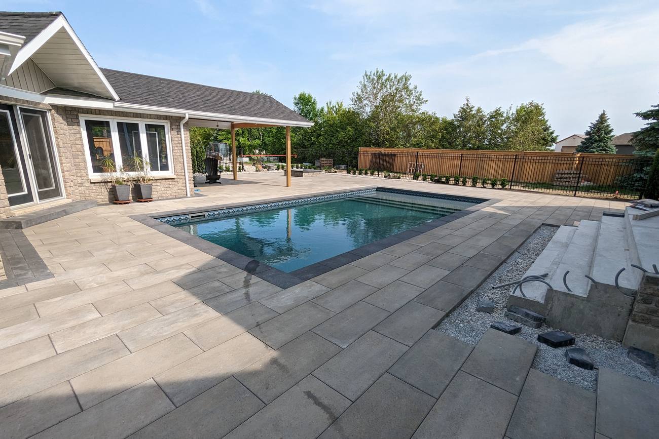 The same pool and patio finished, shot from roughly the render's camera position